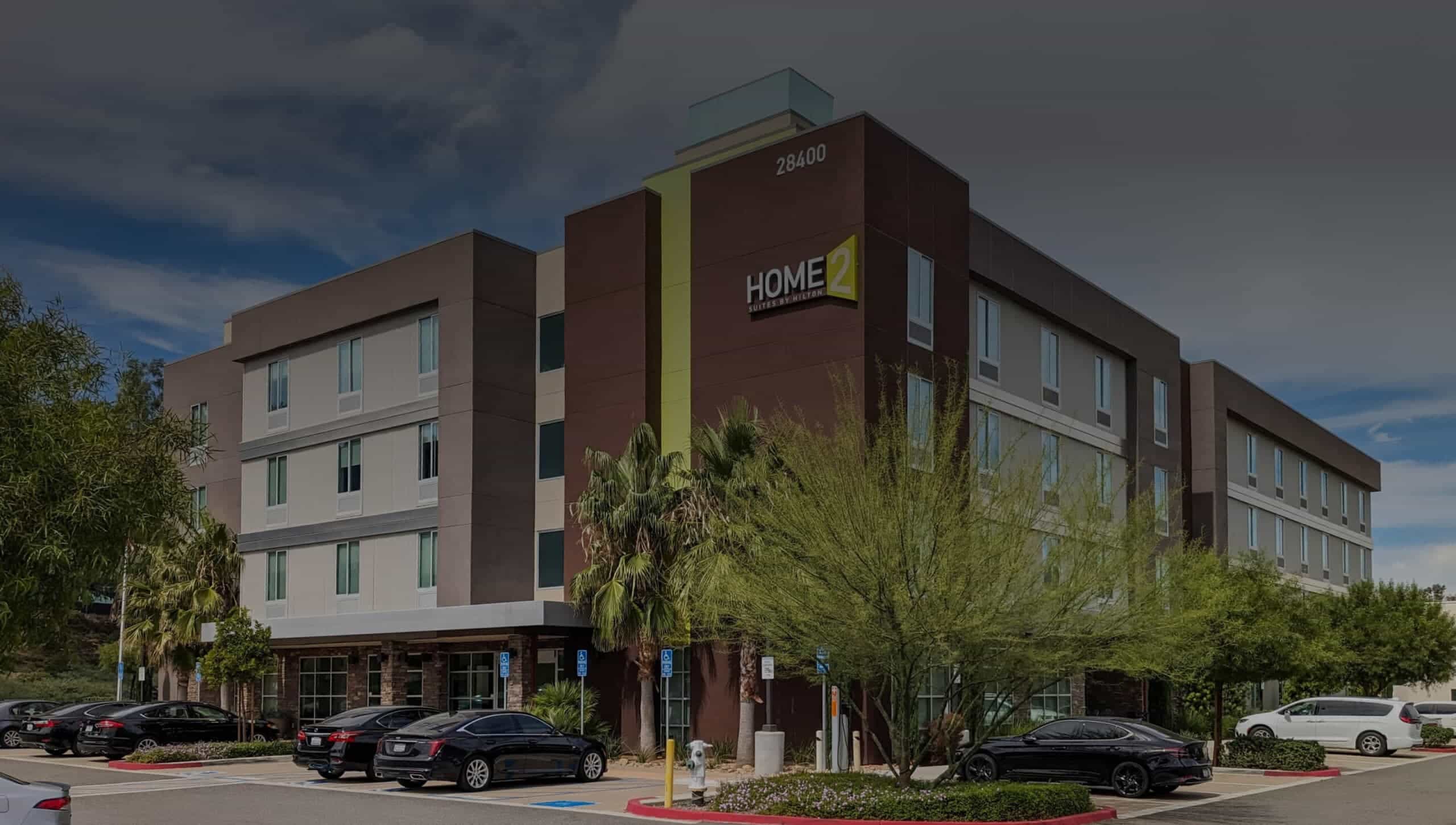 Image of Home2 Hotel front view with dark overlay